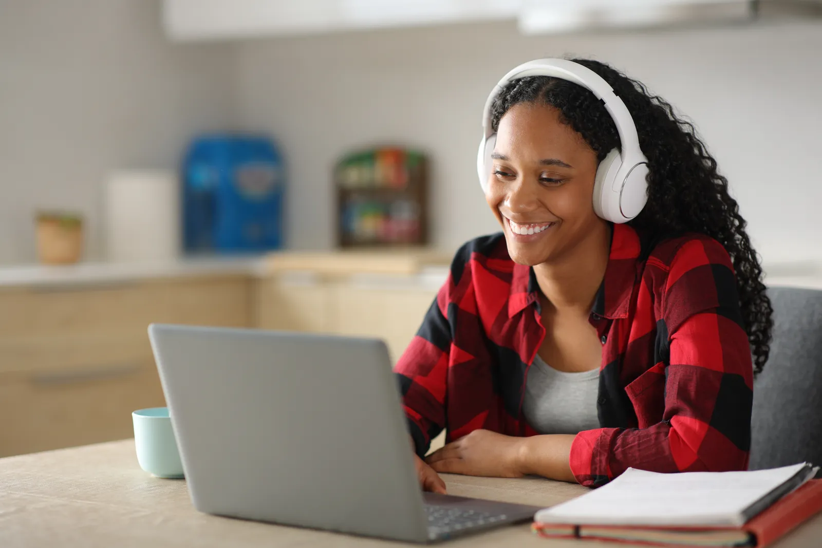 A woman with headphones smiling during an online lesson