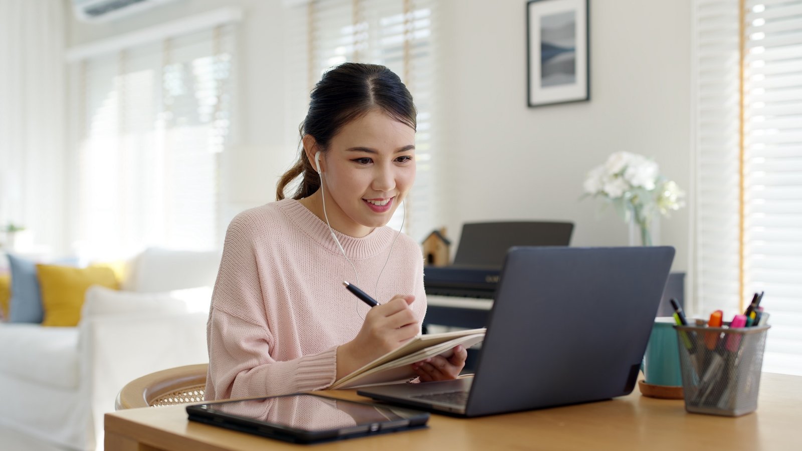 A student taking notes during an online lesson